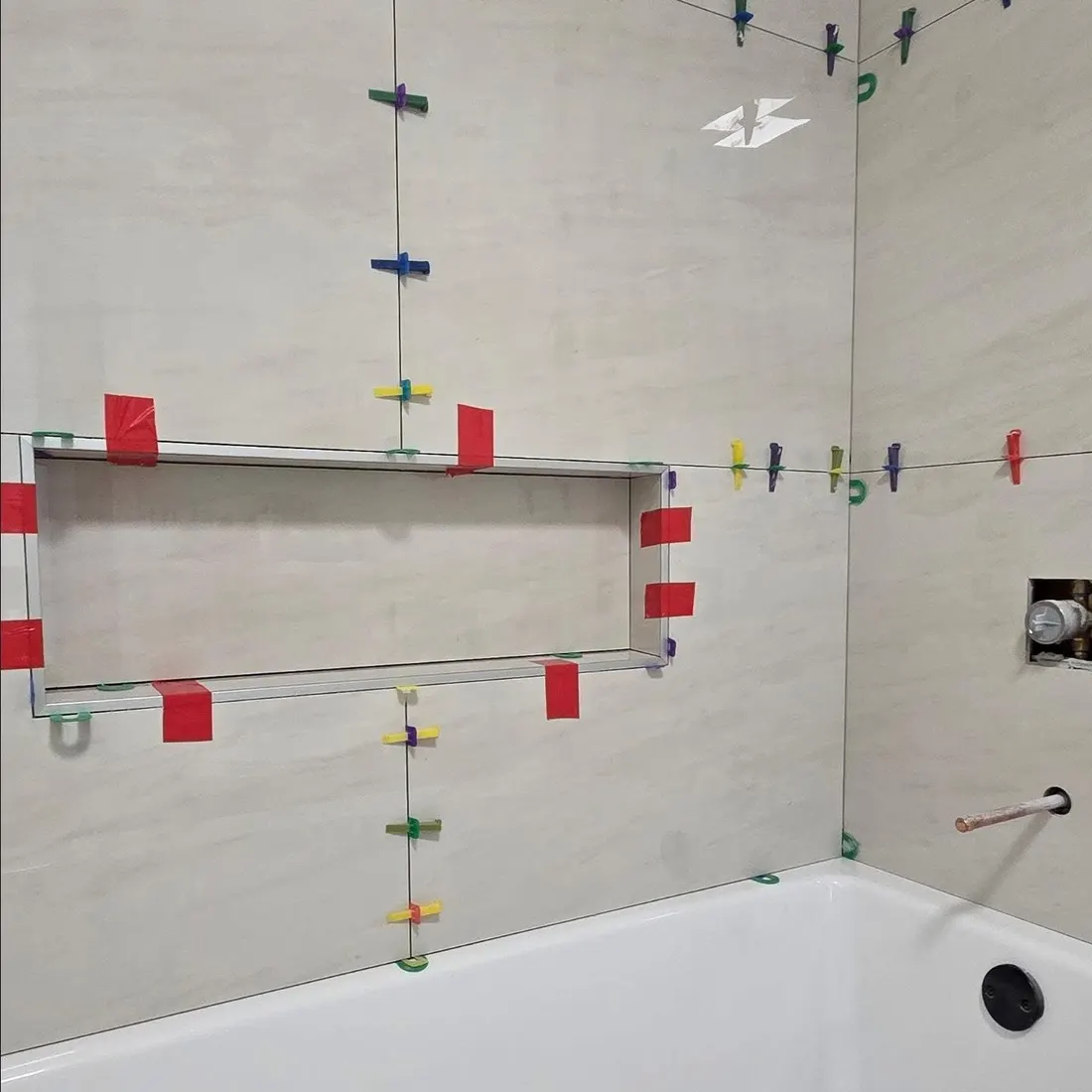 Tub walls going up, spacers keeping the tiles flush