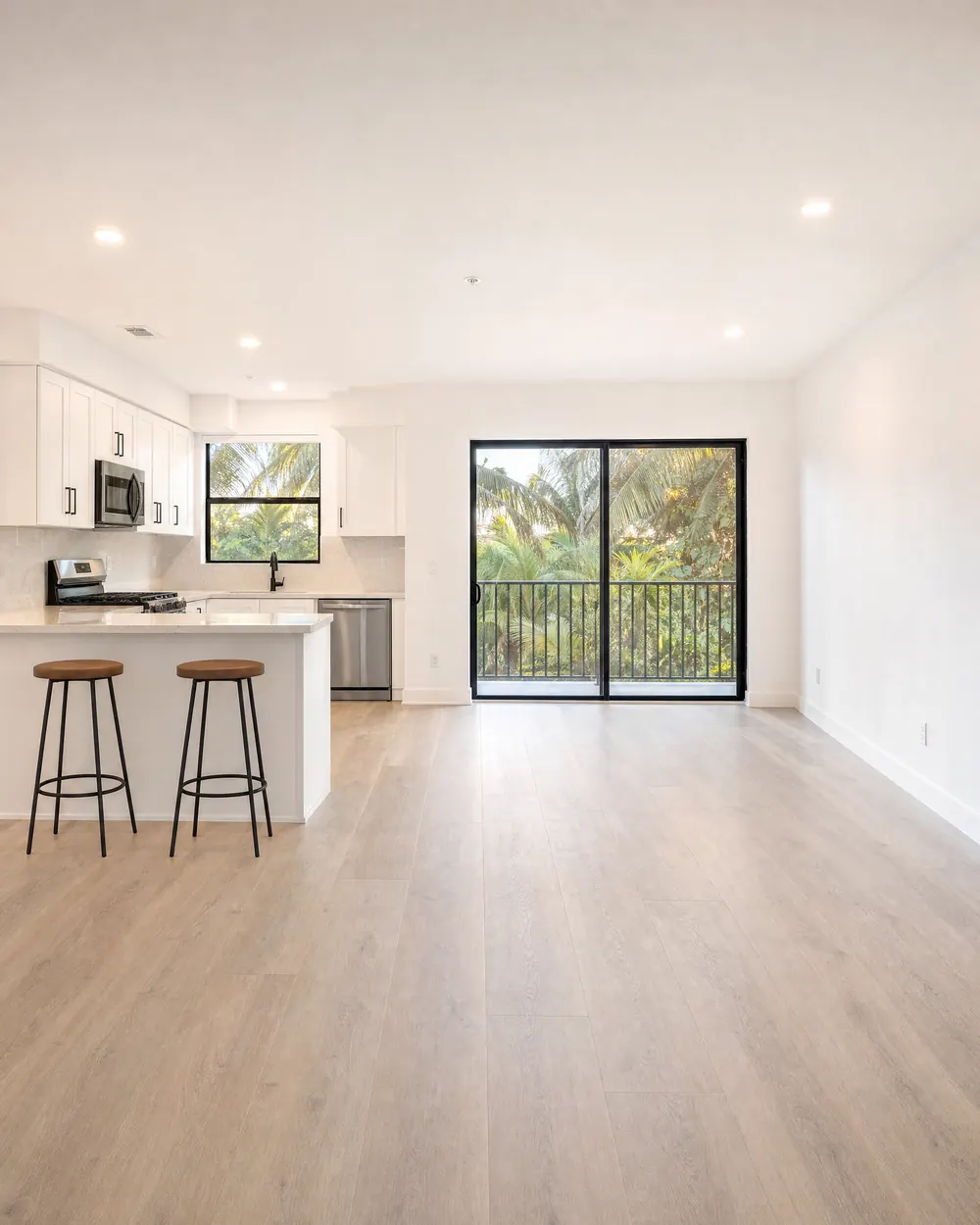 Empty condo unit with new floors, white kitchen and fresh paint, ready for the next tenant